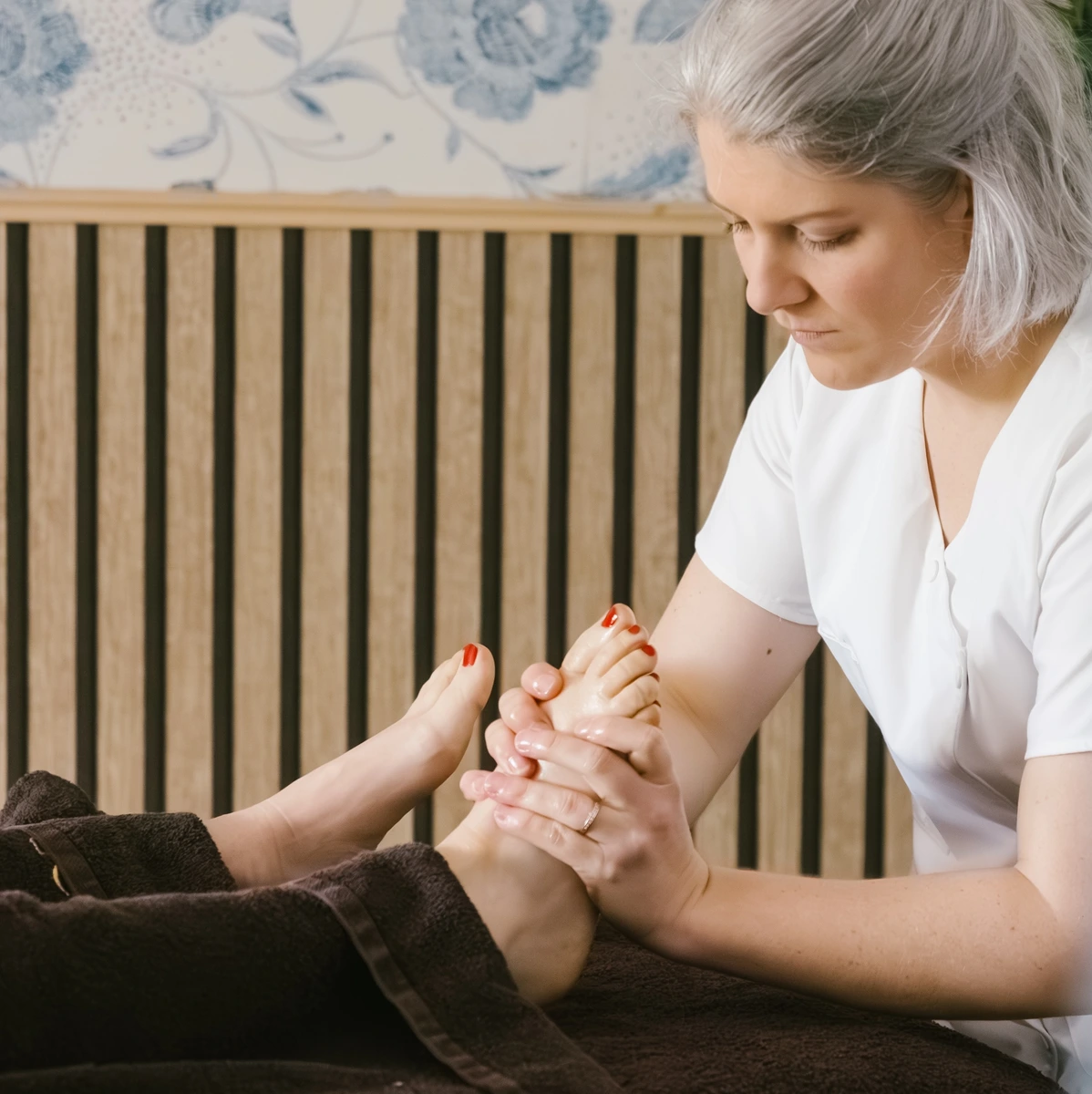 Praticienne réalisant un massage des pieds pendant une séance de massage bien-être